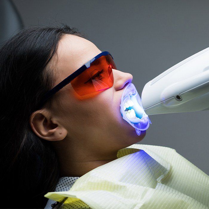 Woman receiving zoom in office teeth whitening treatment